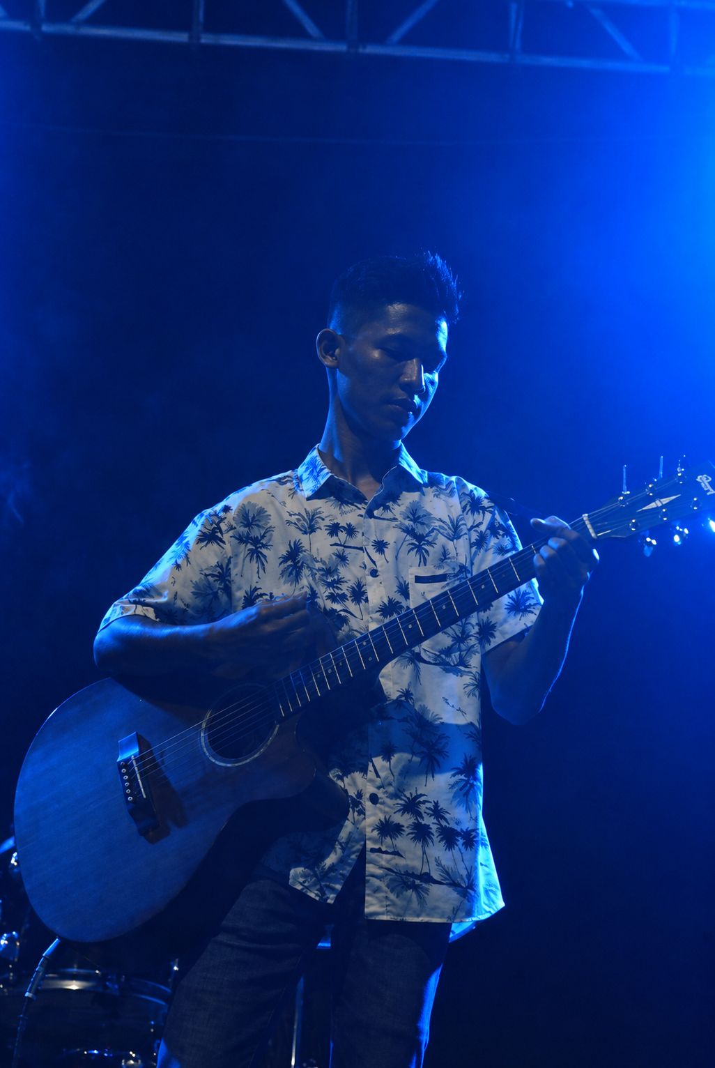 Friesko playing acoustic guitar on stage